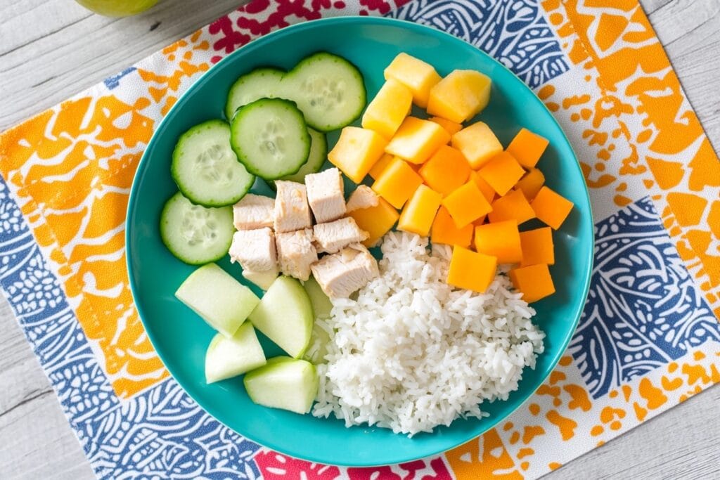 A Colorful, Balanced Toddler Meal With Protein, Veggies, Grains, And Fruit, Displayed On A Fun Placemat
