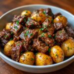 crockpot steak bites and potatoes with steam rising from juicy beef and golden potatoes