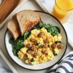 breakfast plate with scrambled eggs, sausage, and toast