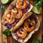 Shrimp tacos with slaw and lime wedges