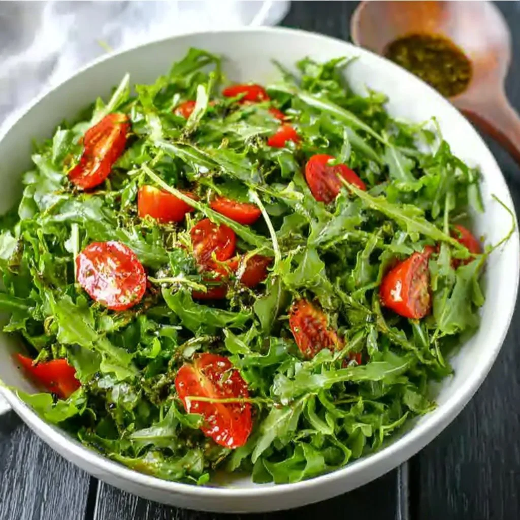 Fresh Arugula Salad topped with lemon balsamic dressing and cherry tomatoes