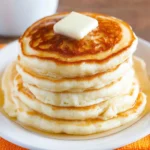 Delicious fluffy pancakes stacked with syrup and berries