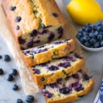 Sliced lemon blueberry breakfast bread with berries on a plate