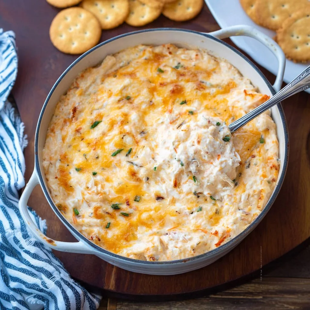 Delicious cheesy hot crab dip served in a bowl with crispy bread.