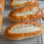 Freshly baked easy hoagie rolls on a wooden cutting board