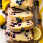 Homemade Lemon Blueberry Bread with a slice showcasing blueberries and lemon zest.