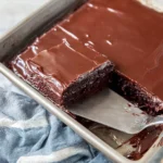 Delicious one bowl chocolate cake topped with chocolate frosting and sprinkles.