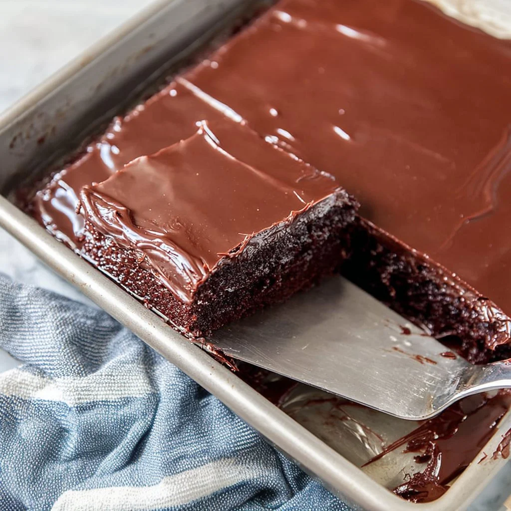 Delicious one bowl chocolate cake topped with chocolate frosting and sprinkles.