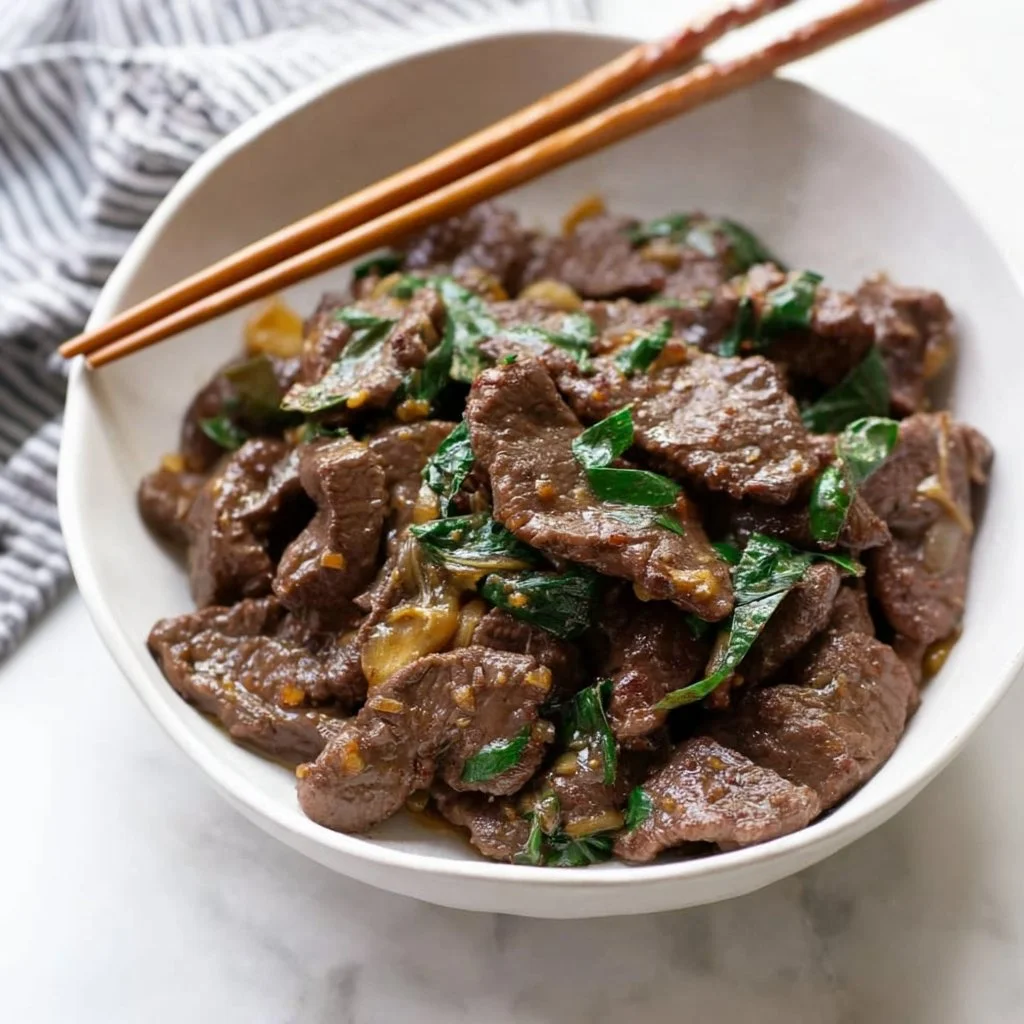 Stir fry beef with ginger and scallions served in a bowl