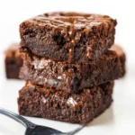 Delicious triple chocolate fudge brownies on a wooden table