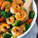 Honey garlic shrimp stir fry served in a colorful dish with fresh vegetables