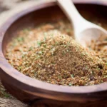 Homemade Jamaican Jerk Seasoning in a bowl with fresh herbs and spices