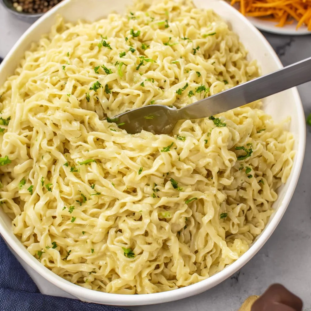 A bowl of Cafeteria Noodles served with vegetables and a sprinkle of herbs