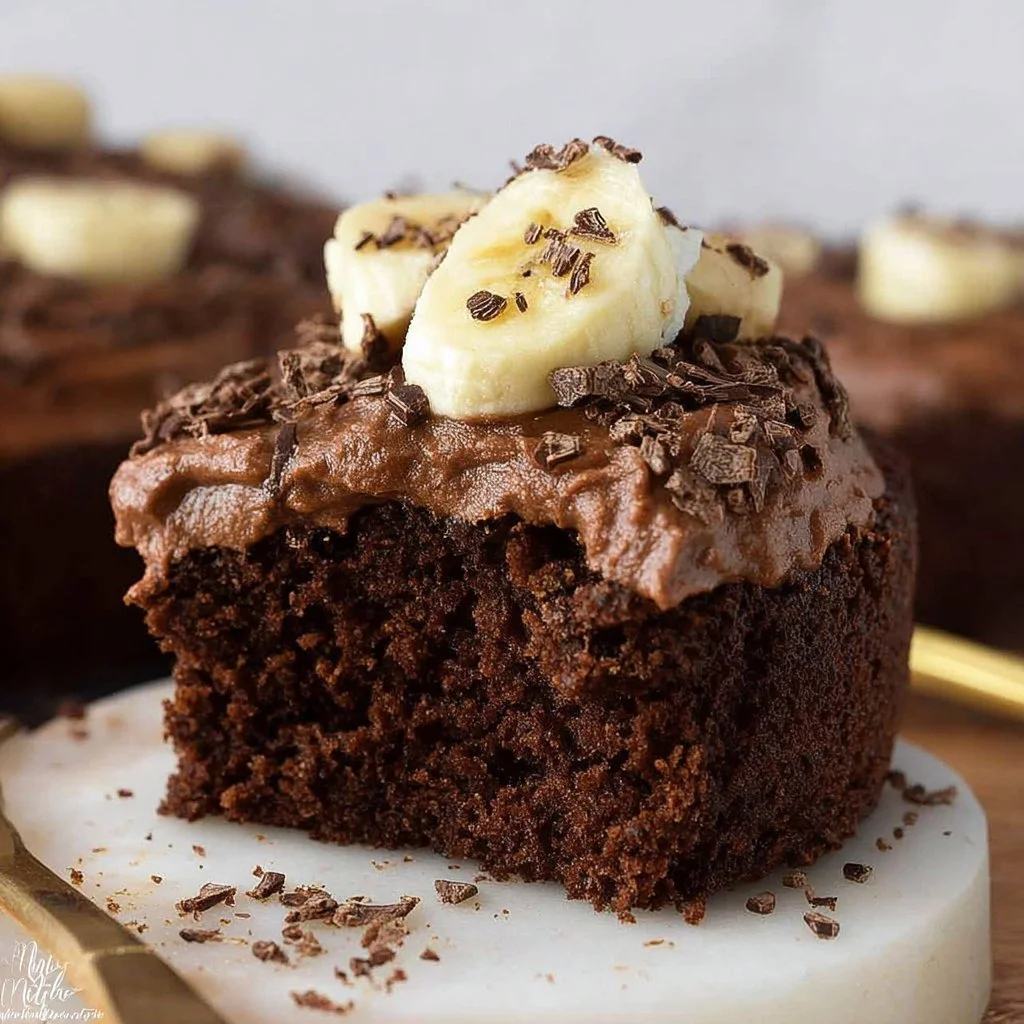 Delicious Chocolate Banana Cake topped with chocolate frosting and banana slices