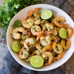 A vibrant plate of cilantro lime shrimp garnished with fresh herbs and lime wedges.