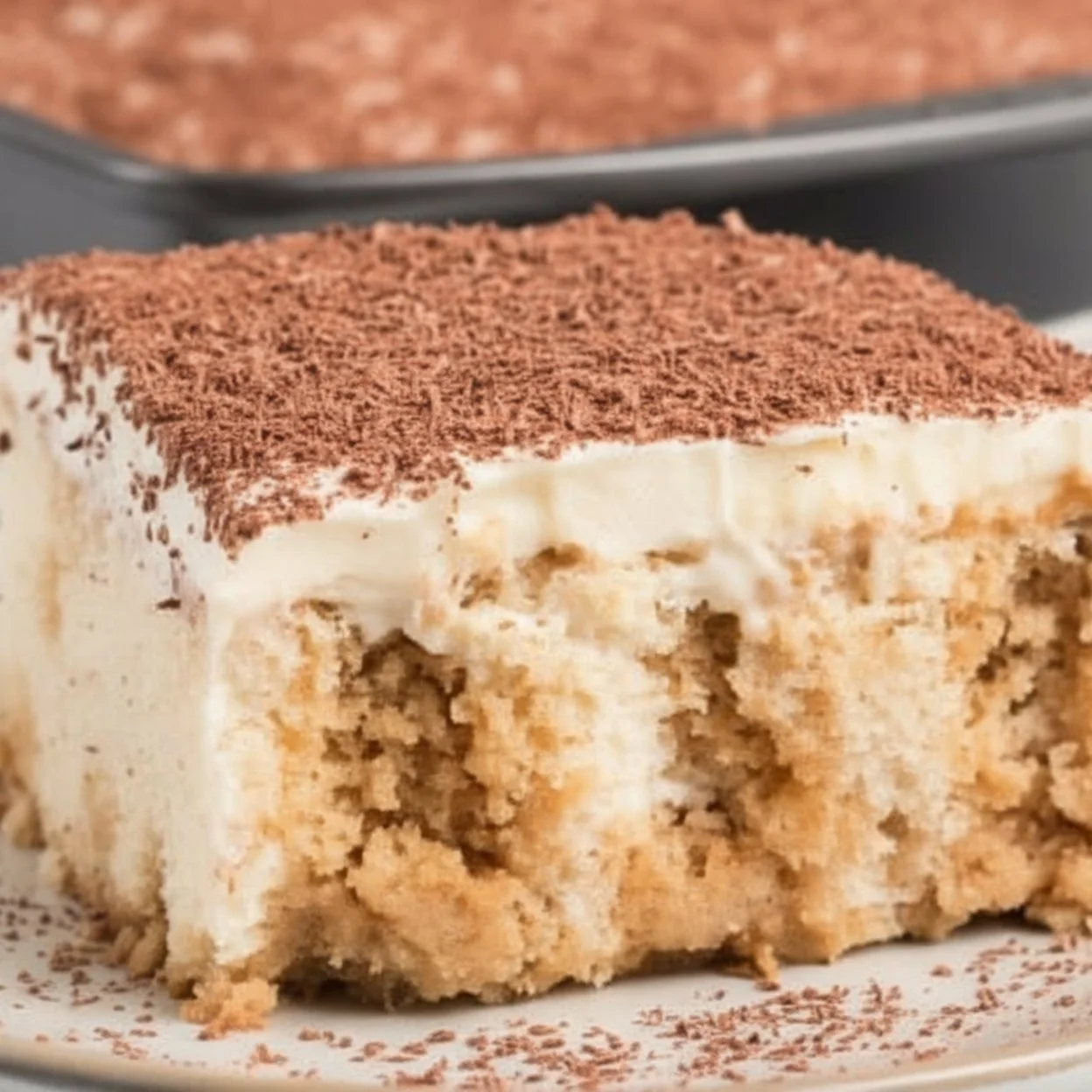 Easy tiramisu poke cake topped with cocoa powder and coffee flavor