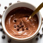 Bowl of creamy Greek yogurt chocolate pudding topped with chocolate shavings