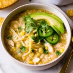 Bowl of healthy white chicken chili with fresh ingredients and toppings