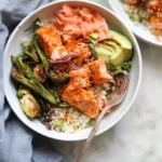 Delicious hot honey salmon bowls served with fresh vegetables and grains.