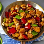 Delicious plate of Kung Pao Chicken served with vegetables and peanuts.