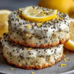 Lemon poppy seed cheesecake cookies on a white plate with lemon zest garnish