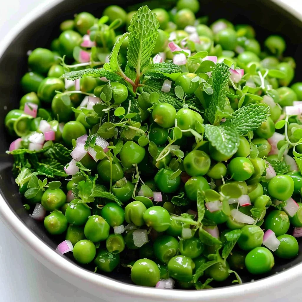 Delicious minty pea salad served in a bowl with fresh mint leaves
