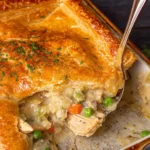 Golden puff pastry chicken pot pie with vegetables and herbs