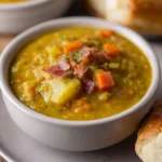 Bowl of slow cooker split pea soup with vegetables and herbs