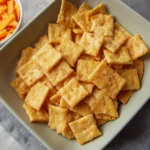 Homemade sourdough cheese crackers served on a wooden board.