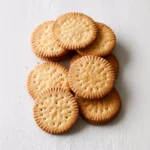 A plate of homemade digestive biscuits next to a cup of tea