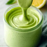 Homemade Green Goddess Dressing served in a bowl with fresh herbs.