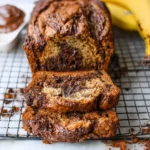 Delicious slice of Nutella banana bread topped with chocolate and bananas.