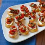 Delicious Tomato Goat Cheese Crostini served on a wooden platter