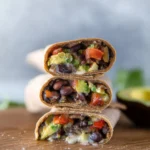Black bean and avocado wraps on a plate, ready to serve.