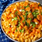 Creamy Buffalo Chicken Mac and Cheese garnished with herbs and served in a bowl.