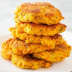 Plate of crispy butternut squash fritters with a dipping sauce