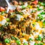 Cheesy beef taco skillet in a pan with fresh toppings and melted cheese