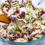 Bowl of classic chicken salad with fresh vegetables and dressing