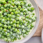 Delicious dish of creamed peas served in a bowl with a garnish
