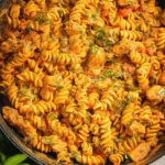 A delicious plate of creamy tomato chicken pasta garnished with fresh herbs.