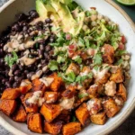 Crispy roasted sweet potato black bean bowl with vibrant toppings