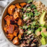 Crispy roasted sweet potato black bean bowl topped with fresh ingredients