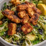 Crispy tofu and roasted Brussels sprout salad served in a bowl
