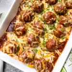 Bowl of enchilada meatballs topped with cheese and cilantro, delicious and comforting.