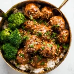 Plate of spicy Firecracker Meatballs garnished with herbs.
