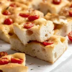 Freshly baked gluten-free focaccia topped with herbs and olive oil