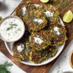 Gluten-free vegan zucchini fritters served on a plate with dipping sauce