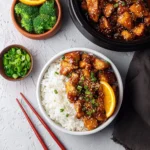 Healthy homemade orange chicken dish with vibrant orange sauce and vegetables
