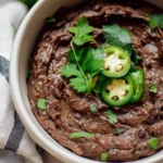 Bowl of homemade refried beans topped with cilantro