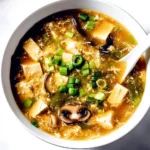 Bowl of Hot and Sour Soup garnished with herbs and spices